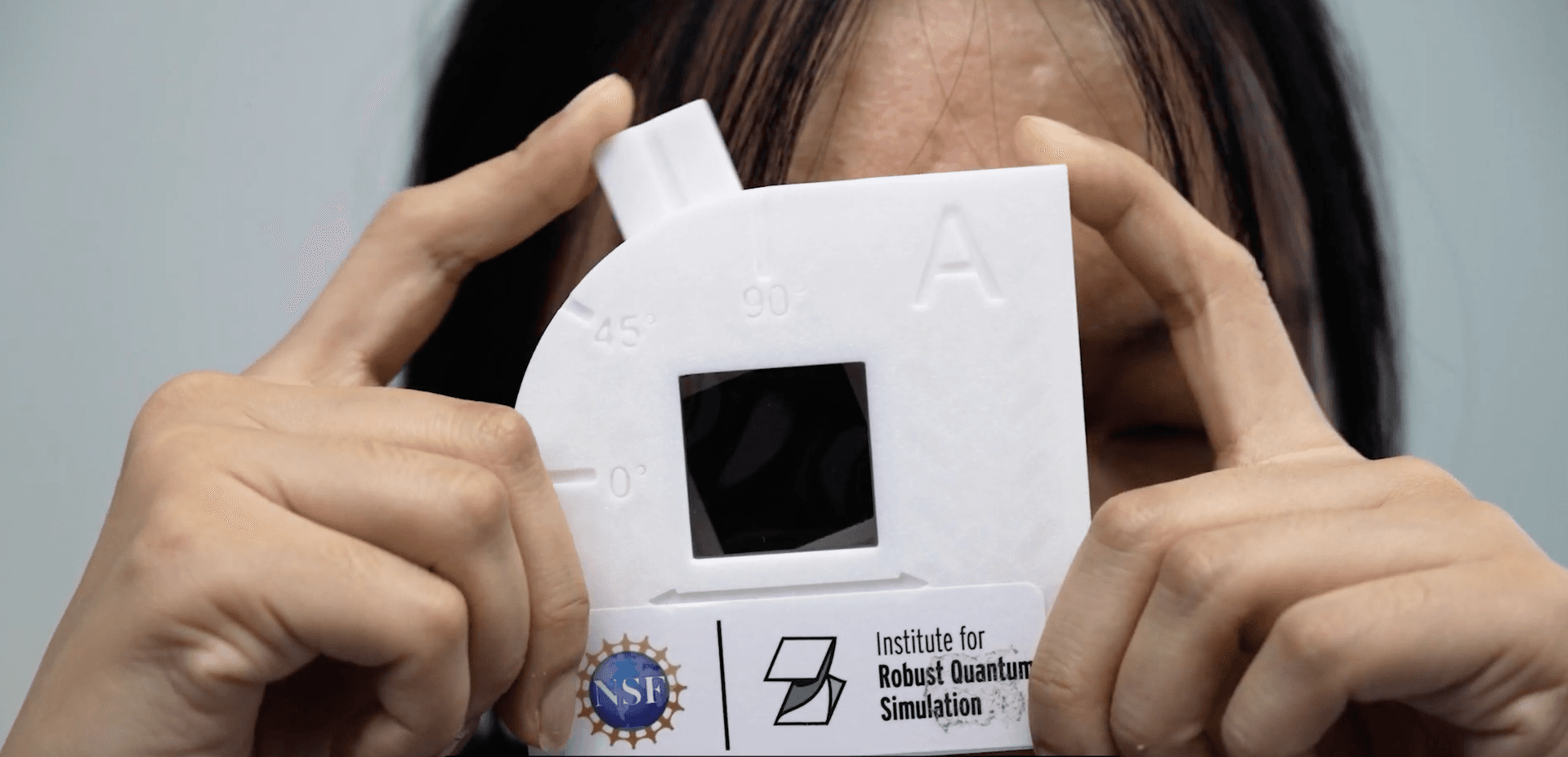 person holding activity kit lens up to eye